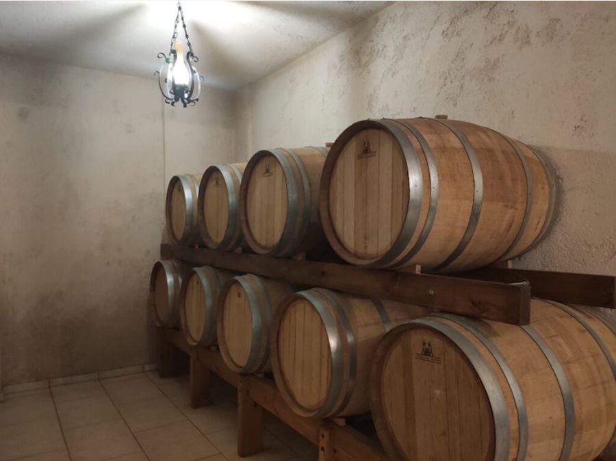 wine wood barrels on top of each other at illuminated 'Stilianou Winery' cellar